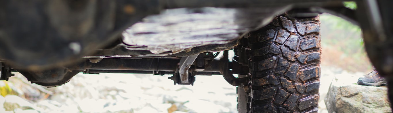 What is Tire and Rim Protection? | Bobby Rahal Toyota | View of the bottom of a truck with a-lot of dirt and debris all around the tires and metal