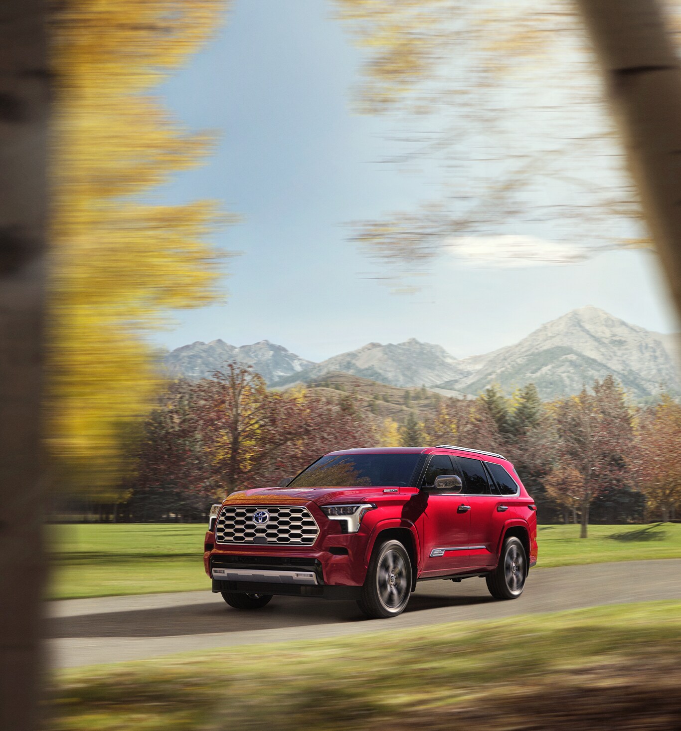 2023 Toyota Sequoia vs. 2023 Chevrolet Tahoe at Bobby Rahal Toyota | Bright red 2023 Toyota Sequoia driving down the road on a nice sunny day