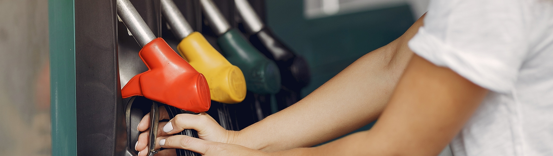 What Type of Gas is Best for My Car? | Bobby Rahal Toyota in Mechanicsburg, PA | Hand on gas red gas nozzle in front of gas stand