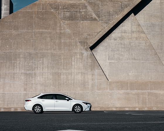 Compare the 2022 Toyota Corolla vs. the 2021 Subaru Impreza at Bobby Rahal Toyota | Corolla by cement wall