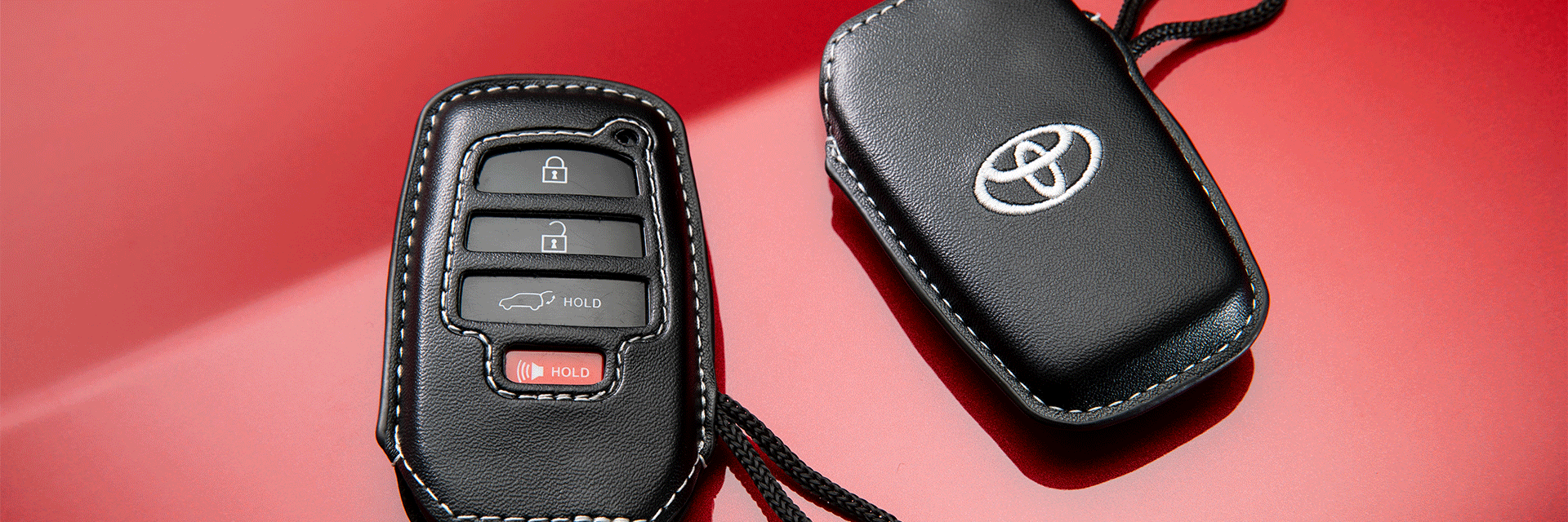 High Cost of Replacing a Car Key | Bobby Rahal Toyota | Two 2022 Toyota Corolla Cross Key Gloves on Red Background