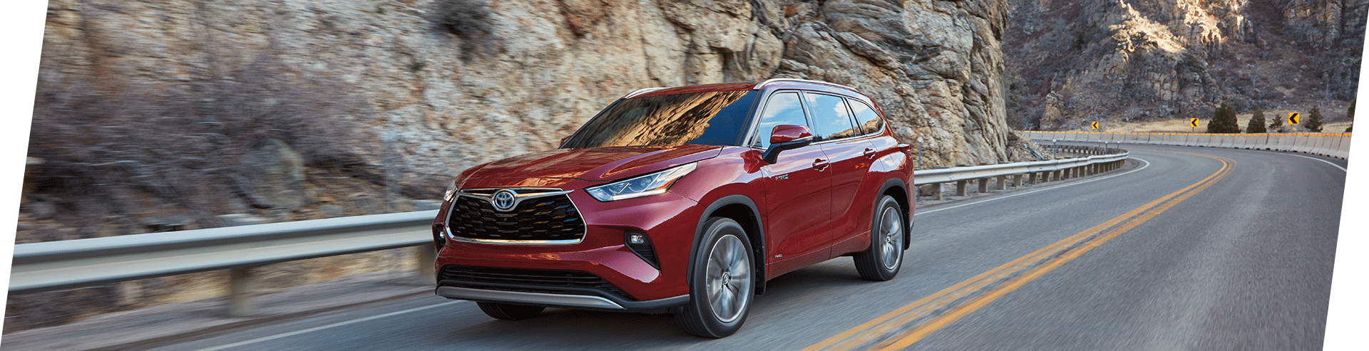 Tips for spring cleaning your car at Bobby Rahal Toyota in Mechanicsburg, PA | 2021 Red Toyota Highlander Hybrid Facing Left Driving on Road next to Cliff