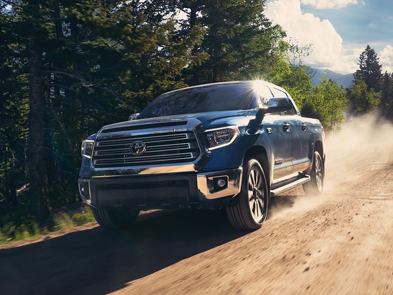 The 2022 Toyota Tundra vs. The 2021 Toyota Tundra at Bobby Rahal Toyota | Blue 2021 Toyota Tundra Driving Fast on Dirt Road