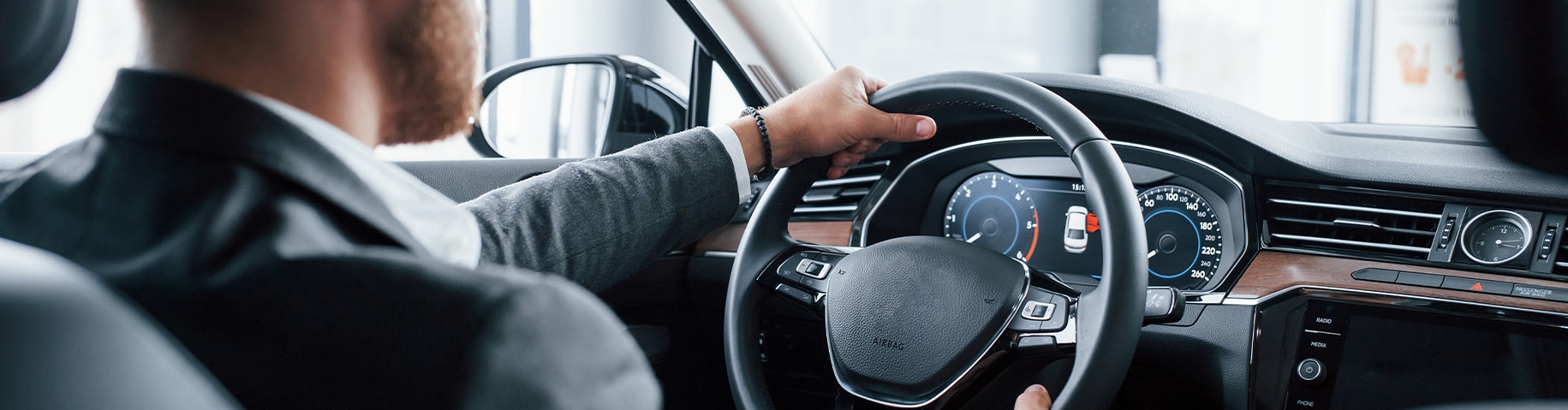 Remove Dead Bugs From Front of Cars at Bobby Rahal Toyota in Mechanicsburg, PA | Rear seat view of a man driving his car with his hands on the steering wheel