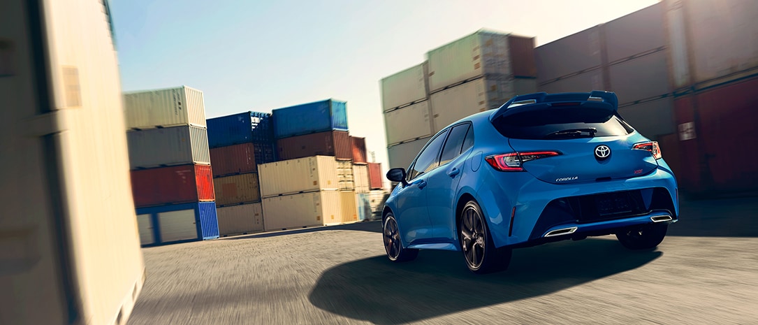 rearview of a 2019 corolla hb driving fast through a shipping container track
