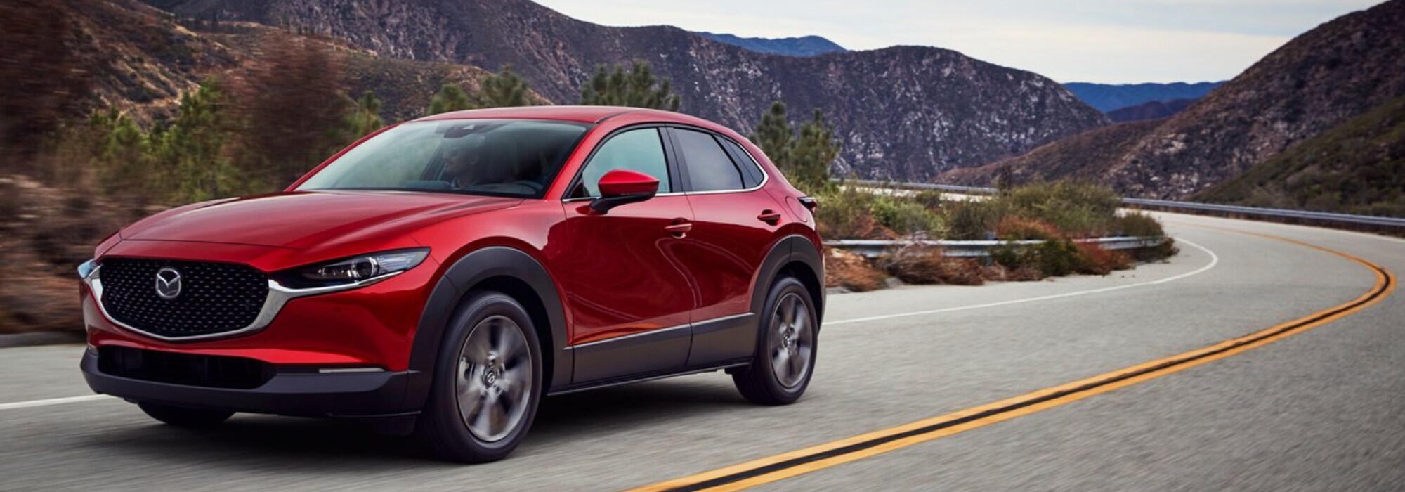 Red 2020 Mazda CX-30 driving through the mountains