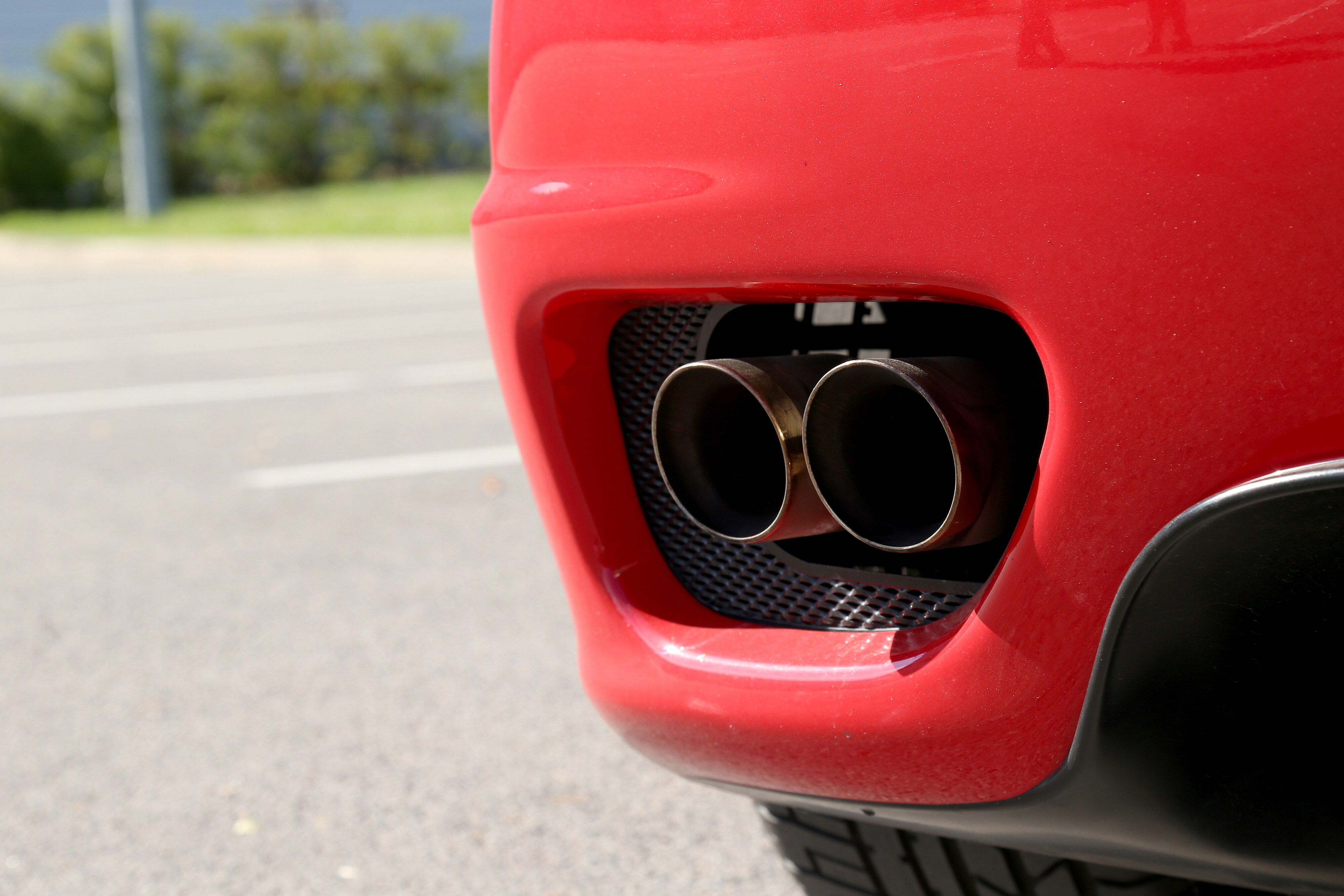 What you can get to personalize your vehicle at Boch Honda, Boch Toyota, Boch Nissan, Boch Hyundai, Boch Chevrolet, Genesis of Norwood, Boch Toyota South, Boch Honda West, Boch Nissan South, & Boch New to You in Massachusetts | Closeup of exhaust on red vehicle