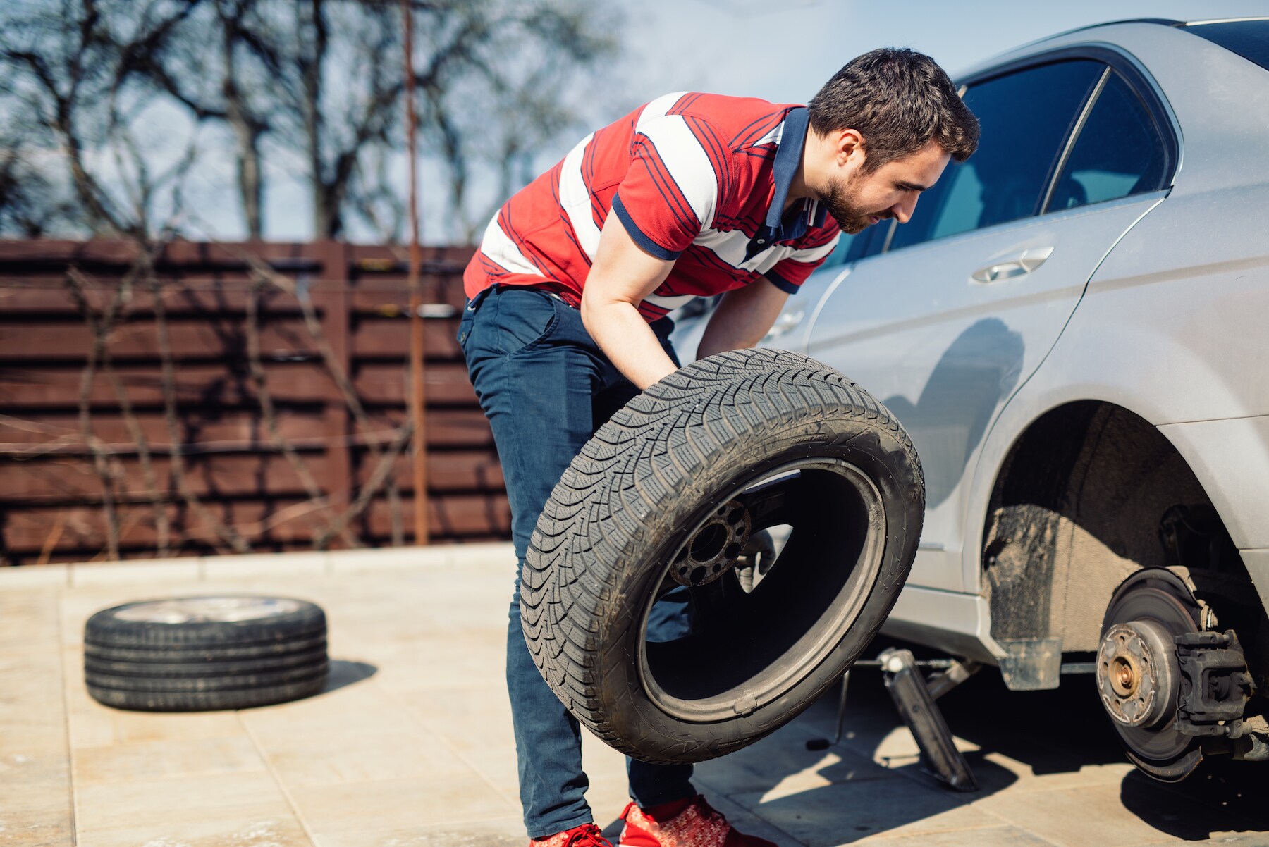 How to change a tire step-by-step guide at Kia of New Bern in New Bern | Man changing car tire