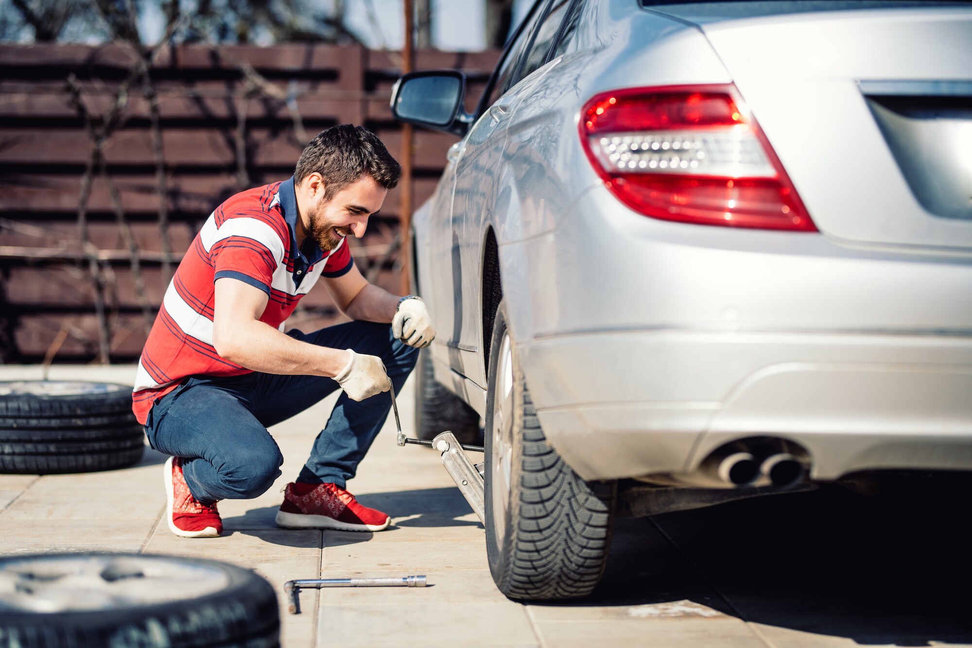 How to change a tire step-by-step guide at Kia of New Bern in New Bern | Man changing car tire
