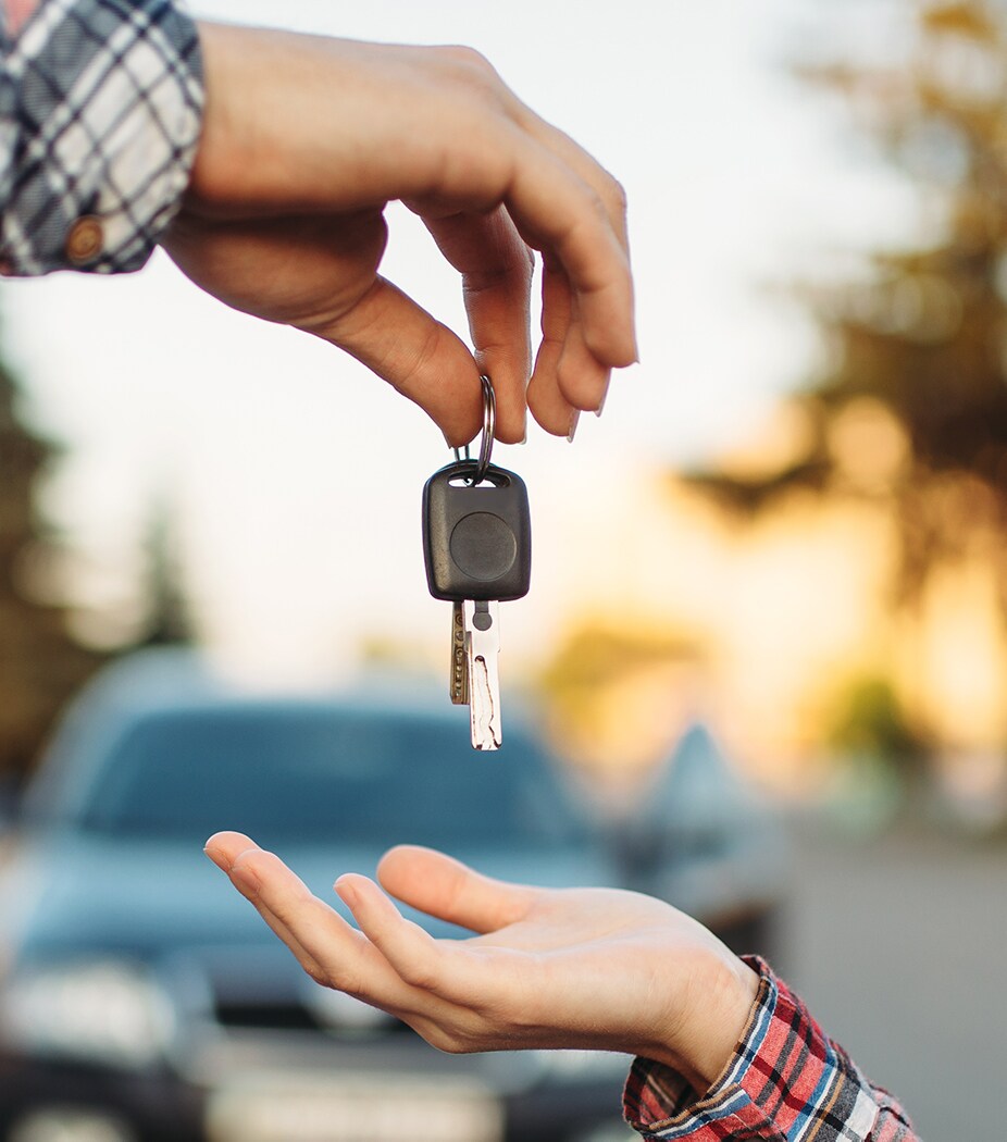 Leasing versus buying a vehicle at Mazda of New Bern in New Bern | Man handing woman car key
