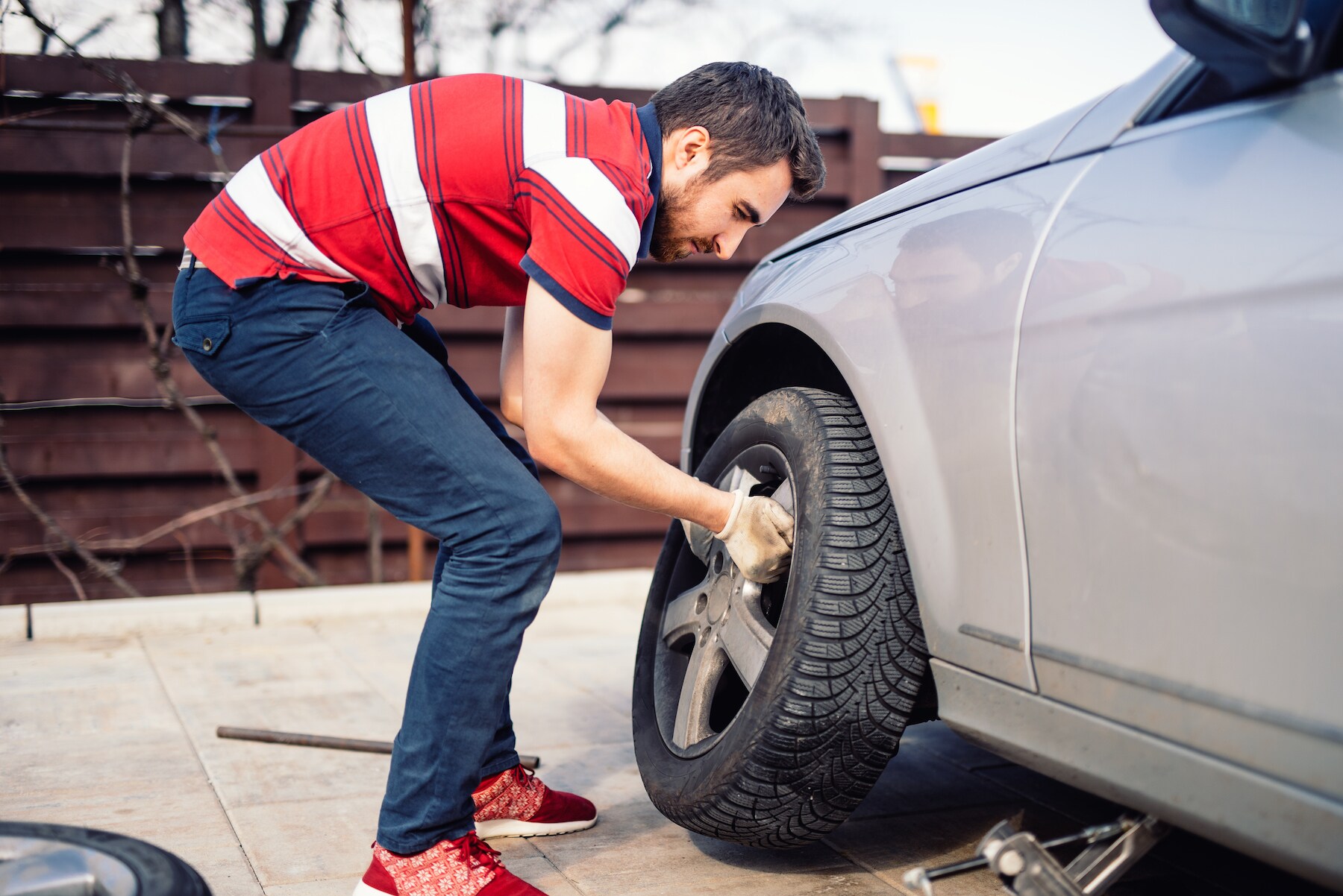 How to change a tire step-by-step guide at Kia of New Bern in New Bern | Man changing car tire