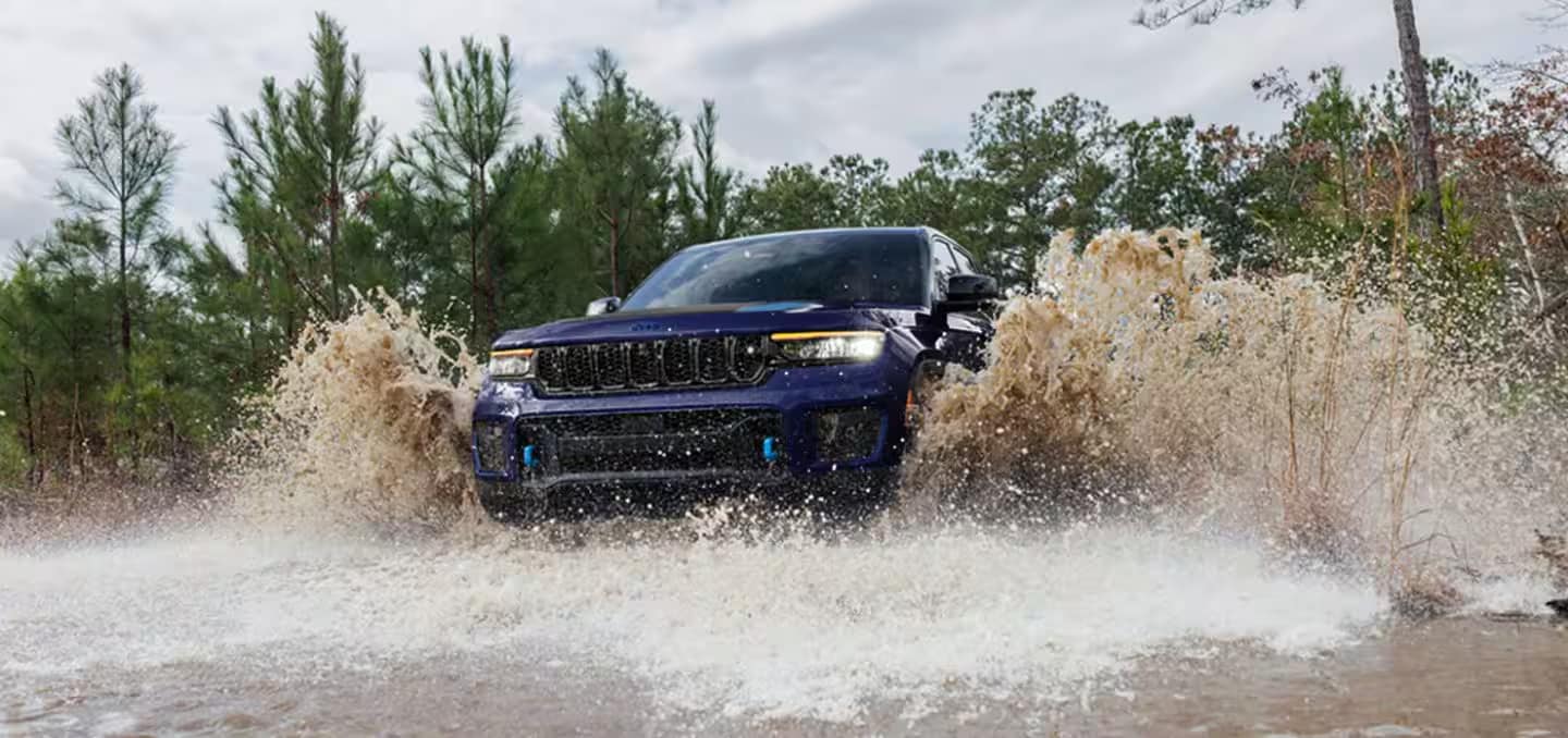 2025 Jeep Grand Cherokee driving through water near Orange