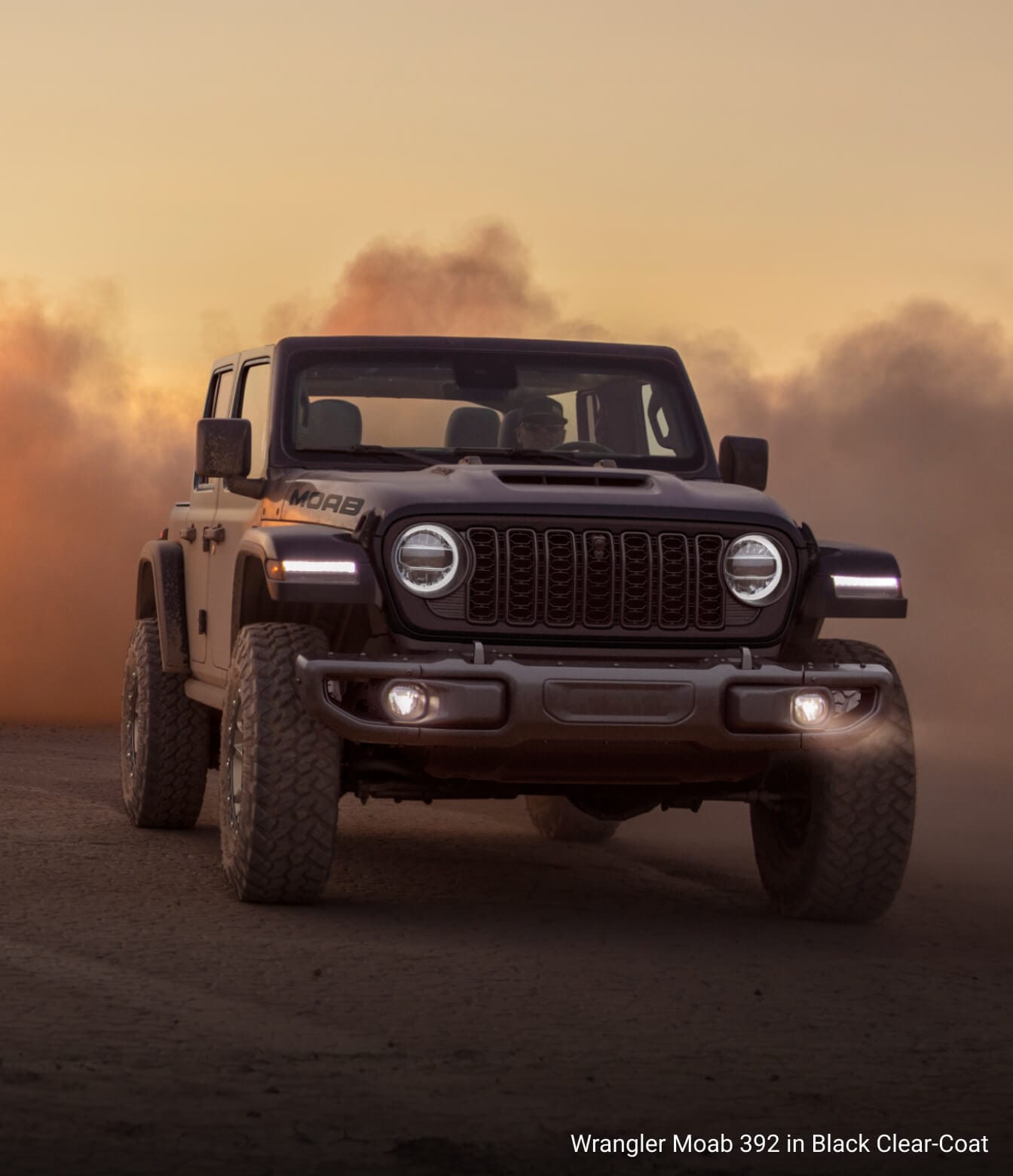 Jeep Wrangler Moab 392 in Black Clear-Coat, driving through a dust cloud