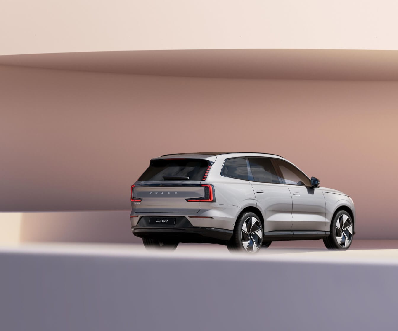 Volvo EX90 electric SUV rear three-quater view showing modern taillights and aerodynamic design in studio setting