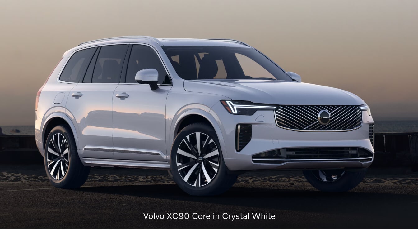 2026 Volvo XC90 Core parked at three-quarters angle on a dark coastal roadway.