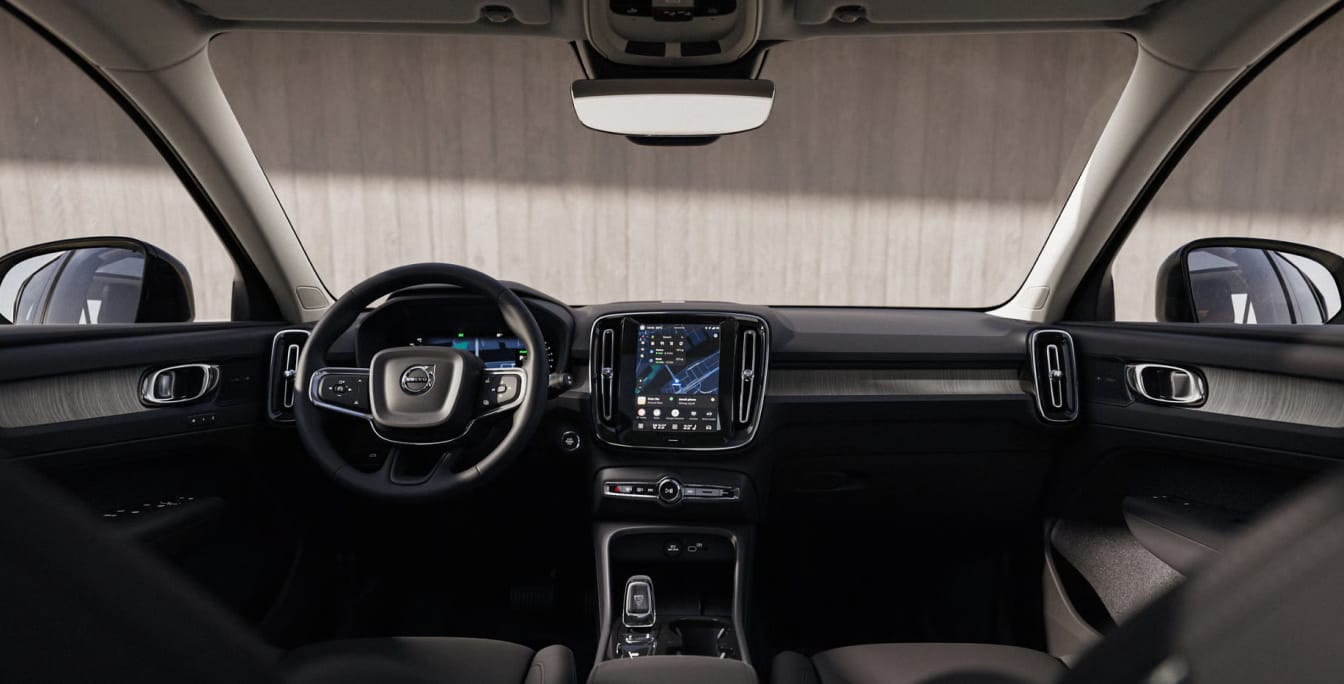 Volvo XC40 interior with black upholstery, digital instrument cluster, and vertical center touchscreen display.