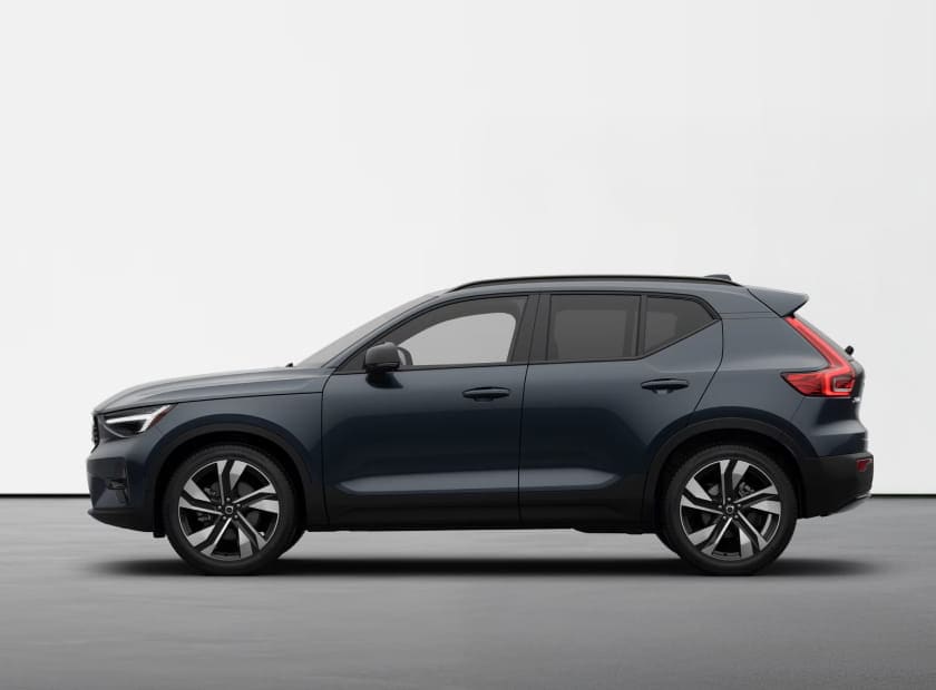 Side profile of a dark blue Volvo XC40 against a white studio background.