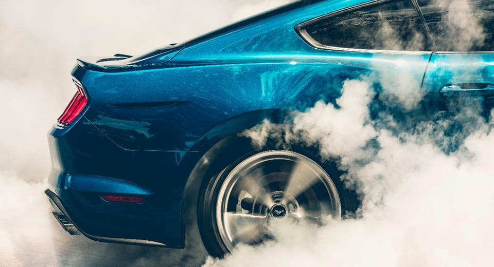 Photo of the rear wheels of a New Ford Mustang performing a burnout - illustrating research showing that driving an exciting car can be good for your health
