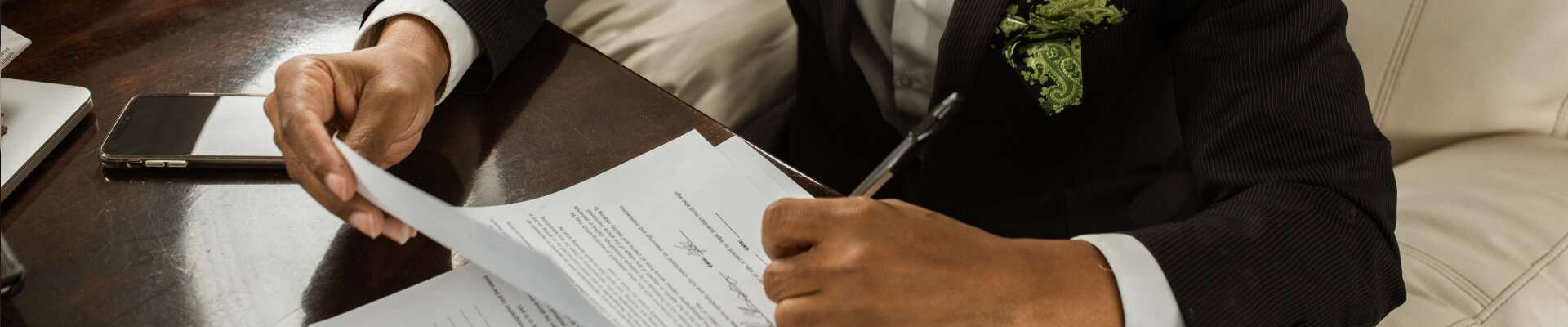 Elegant businessman in black suit signing financing contract.