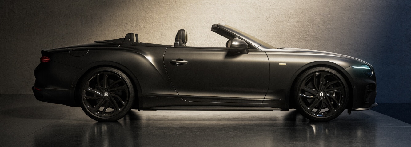 Side profile view of matte black Bentley Mulliner Virtuoso Collection in a dark-lit studio.