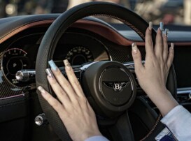 Close-up interior view of a passenger in a Bentley Continental GT sitting inside the luxurious cabin.