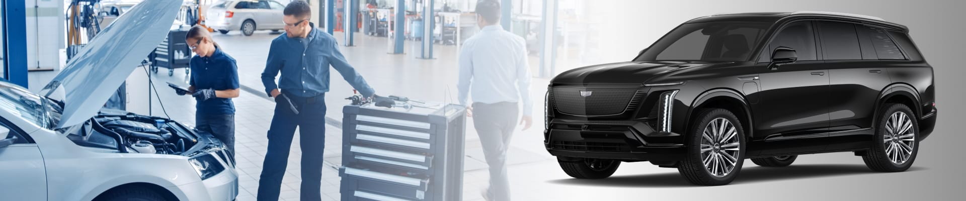In a bright auto workshop, two technicians work on a car’s engine with tools. A sleek, shiny black SUV is prominently displayed.