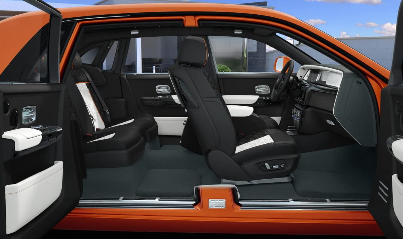 2026 Rolls-Royce Phantom car interior with black leather seats accented by orange piping and embroidered headrests. Sleek design, exudes elegance and comfort.