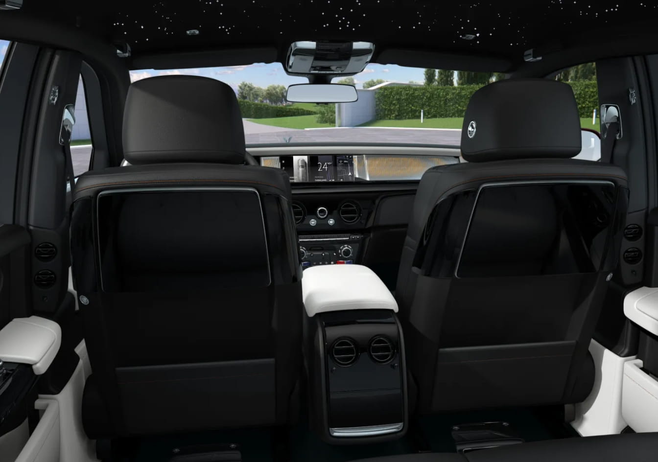 2026 Rolls-Royce Phantom interior, a central console with vents, a panoramic sunroof, and lush greenery outside.