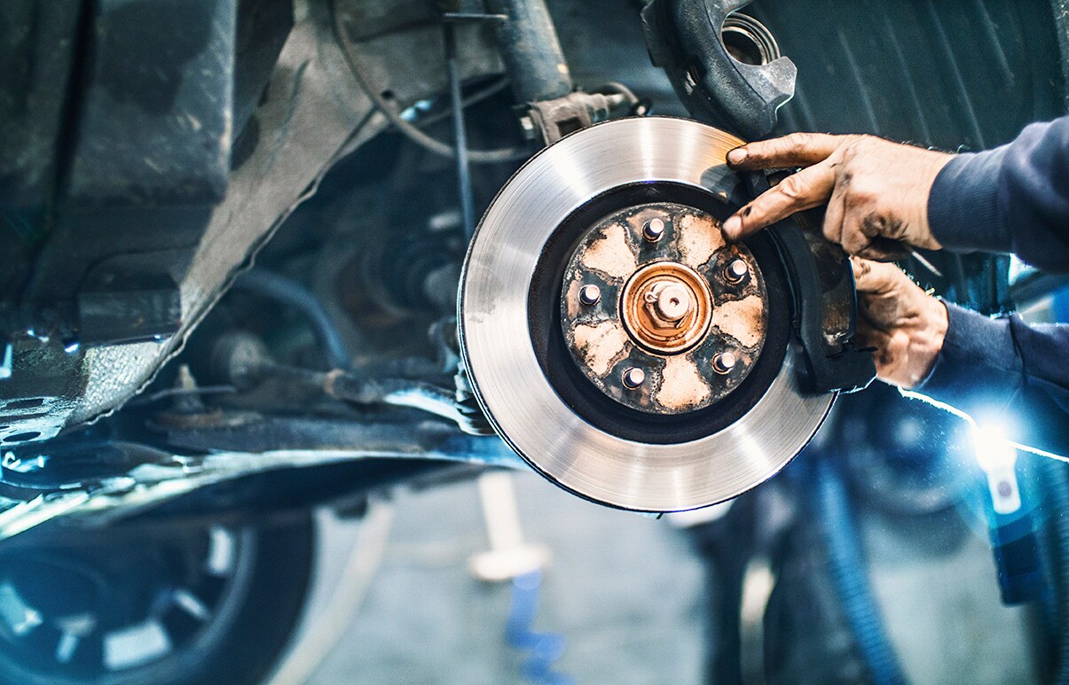 a brake pad and rotor on a Subaru getting serviced