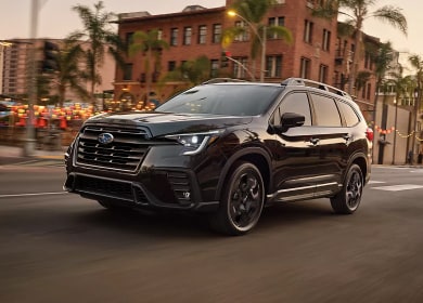 2025 Subaru Ascent in black driving through town streets at dusk near Danbury, CT