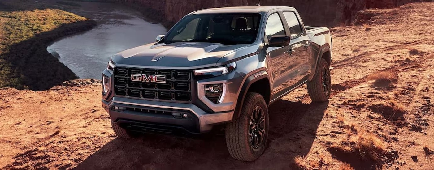 A silver 2024 GMC Canyon parked near a cliff.
