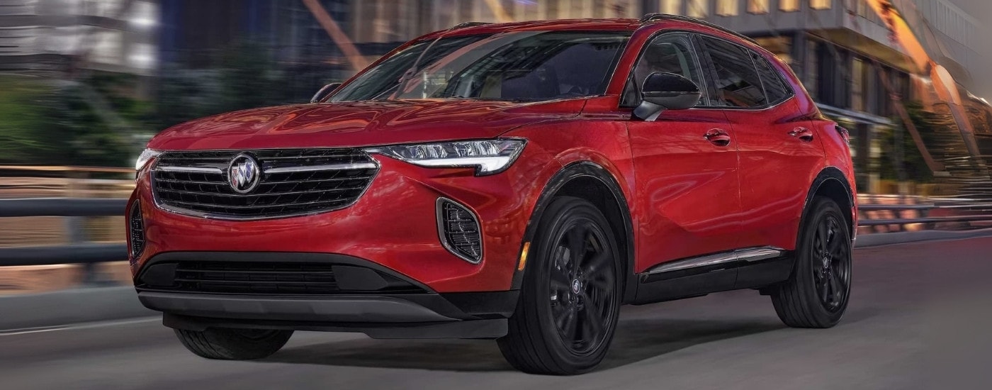 A red 2023 Buick Envision ST driving over a bridge.