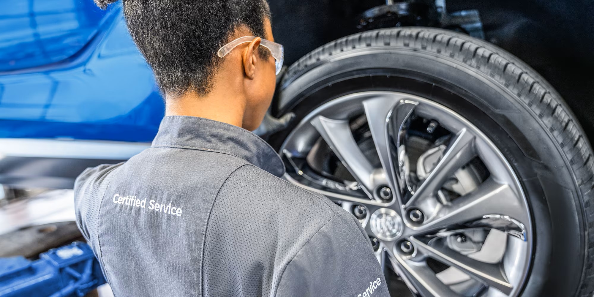 Certified Service technician working on a Buick alloy wheel and tire at Brickell Buick GMC