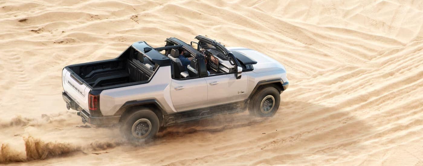 A white 2024 GMC Hummer EV Pickup driving off-road.