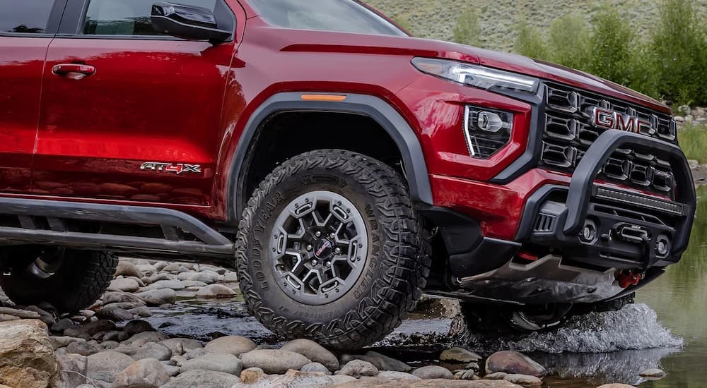 Red 2026 GMC Canyon off-roading on rocks