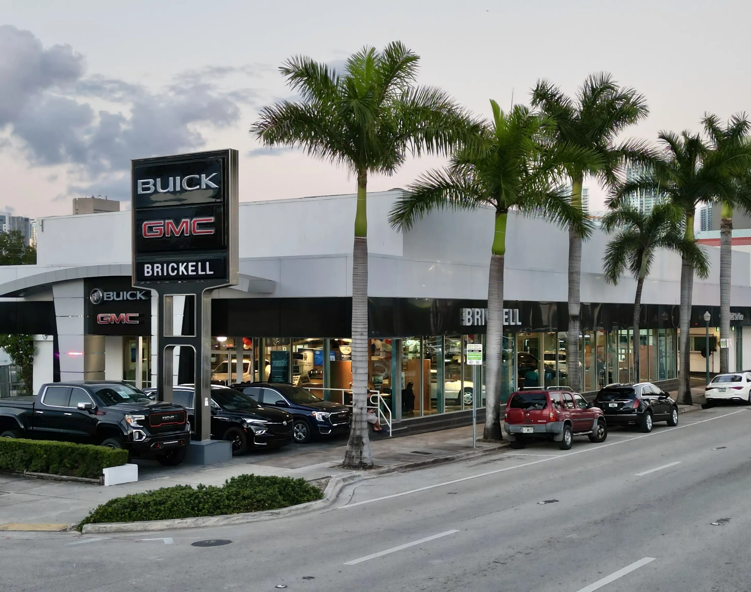 Brickell Buick GMC dealership at 665 SW 8th Street in Miami, with the Buick and GMC pylon sign and palm trees along Calle Ocho