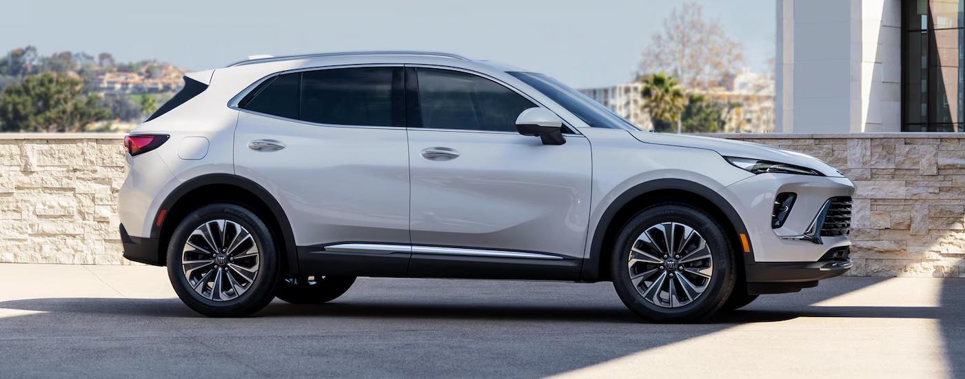 White 2025 Buick Envision parked near a stone wall.