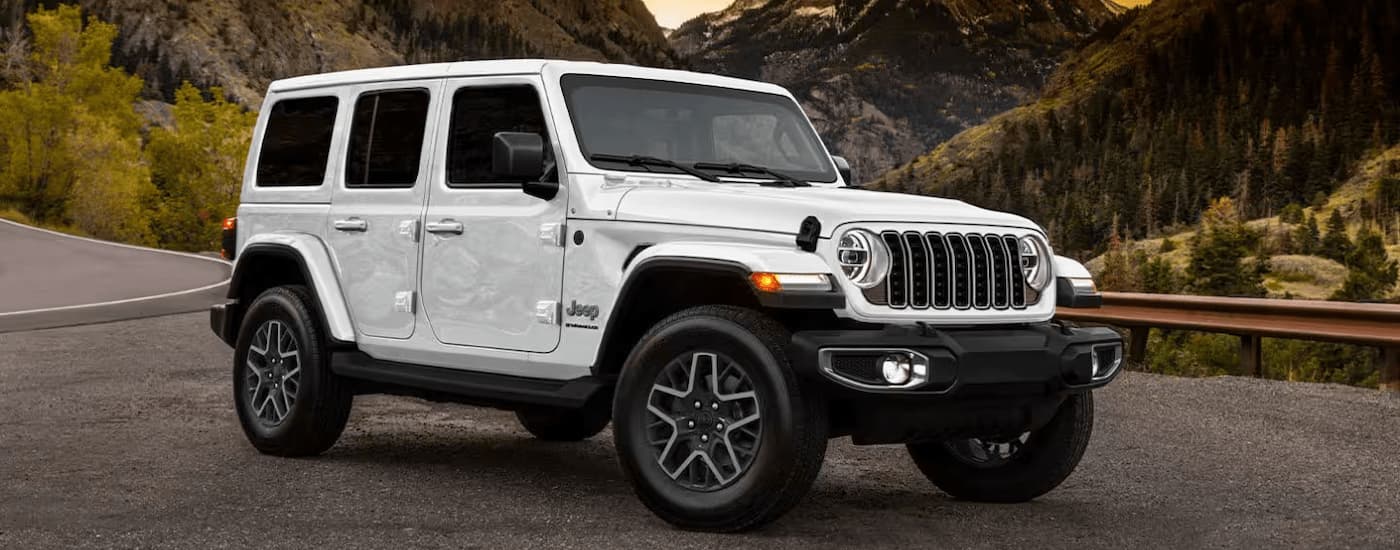 White 2025 Jeep Wrangler Sport parked with a view of trees