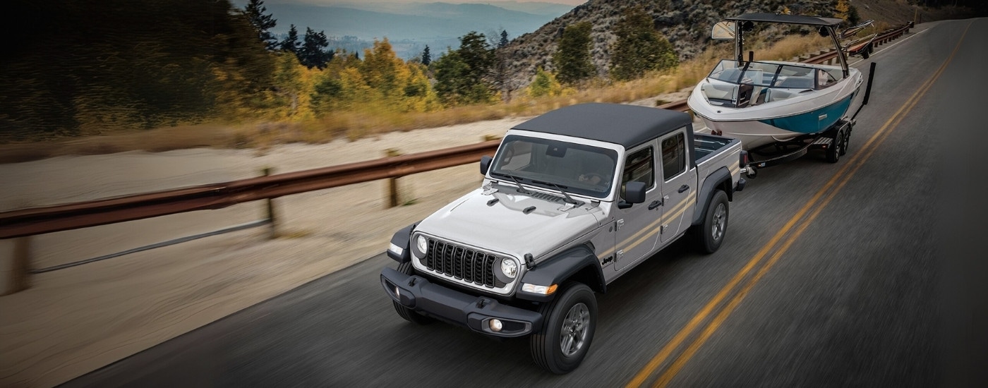 Silver 2025 Jeep Gladiator Sport S towing a boat