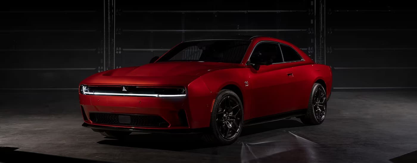 Red 2025 Dodge Charger Daytona for sale parked in a dark garage