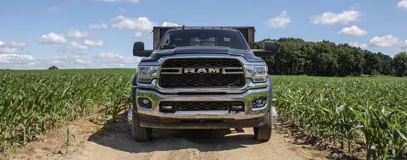 A grey 2023 Ram 3500 Chassis Cab parked on a dirt path after leaving a Ram dealer in Miami.