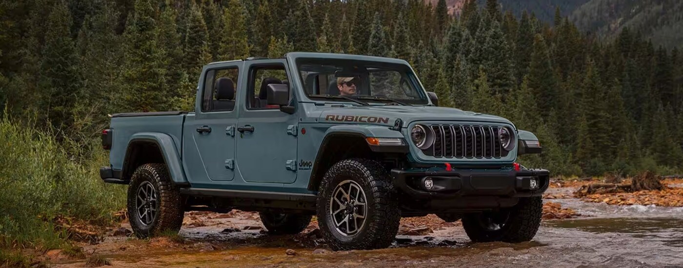 A grey 2025 Jeep Gladiator Rubicon is parked off-road.
