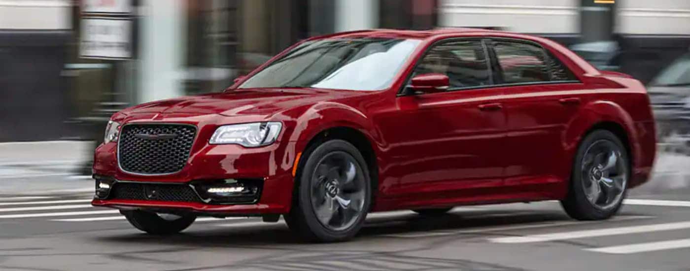Red 2021 Chrysler 300 driving through a city
