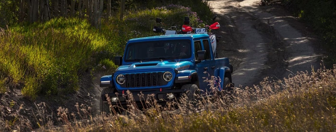 A blue 2025 Jeep Gladiator on a trail after leaving a Jeep dealer near Fort Lauderdale.