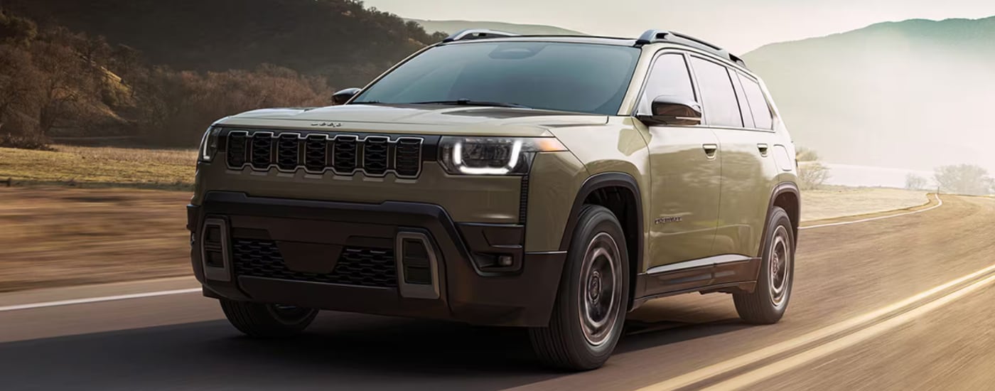 Green 2026 Jeep Cherokee driving to a Jeep dealer near North Miami Beach