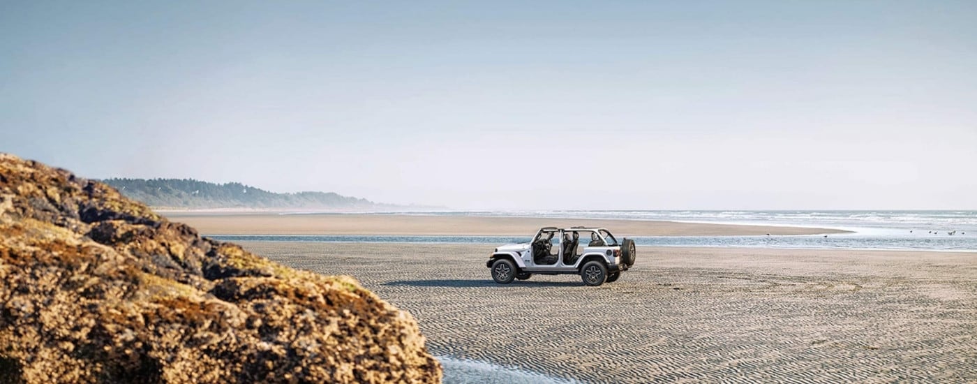 White 2026 Jeep Wrangler parked on a shore