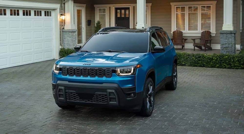 A blue 2026 Jeep Cherokee Hybrid parked in a driveway