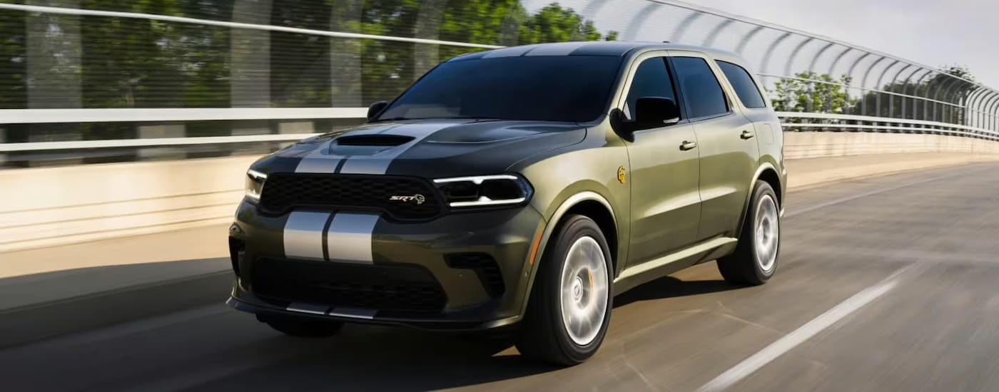 A green 2026 Dodge Durango SRT driving from a dealer near Doral