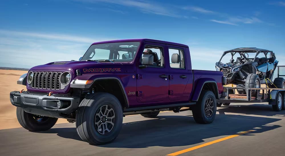 A purple 2026 Jeep Gladiator Reign towing a trailer 