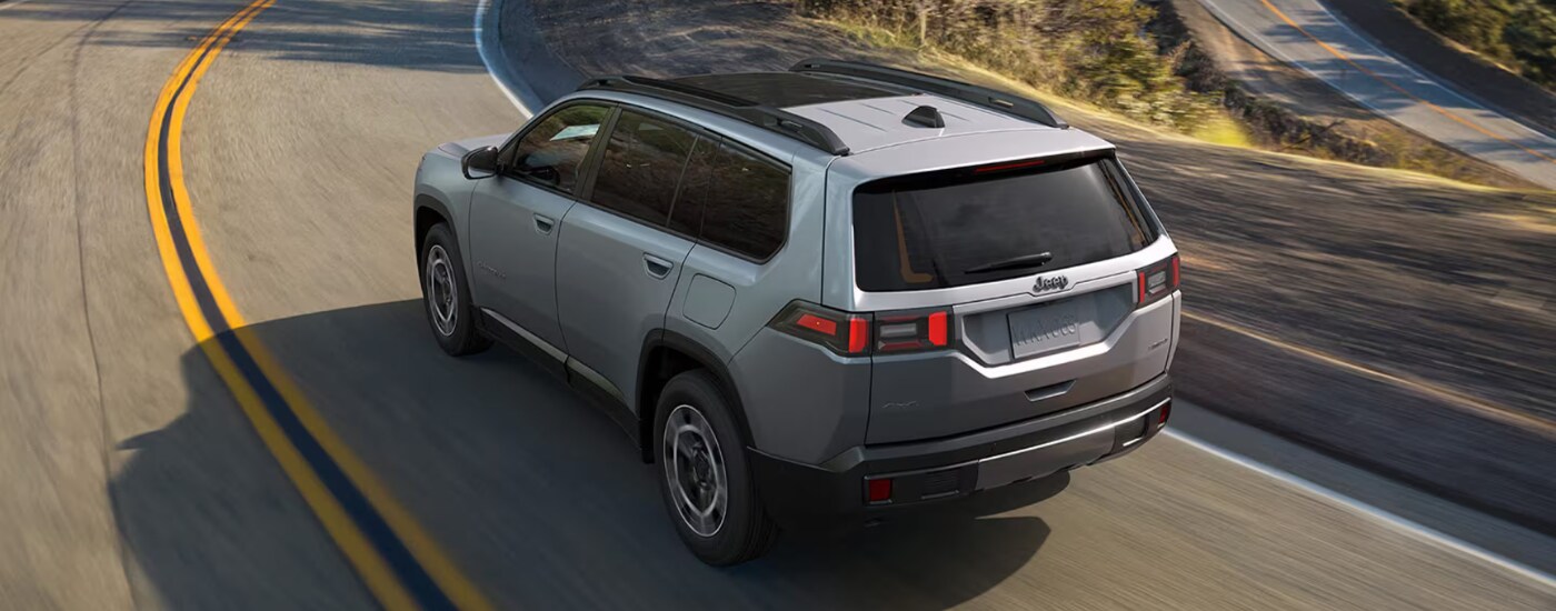 Silver 2026 Jeep Cherokee from the rear on an open road